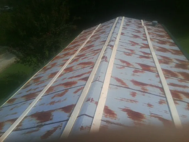 Rusted metal roof panels with new wood purlins before replacement — Storm Damage Roof Repair in Stanhope by Roofing Brothers